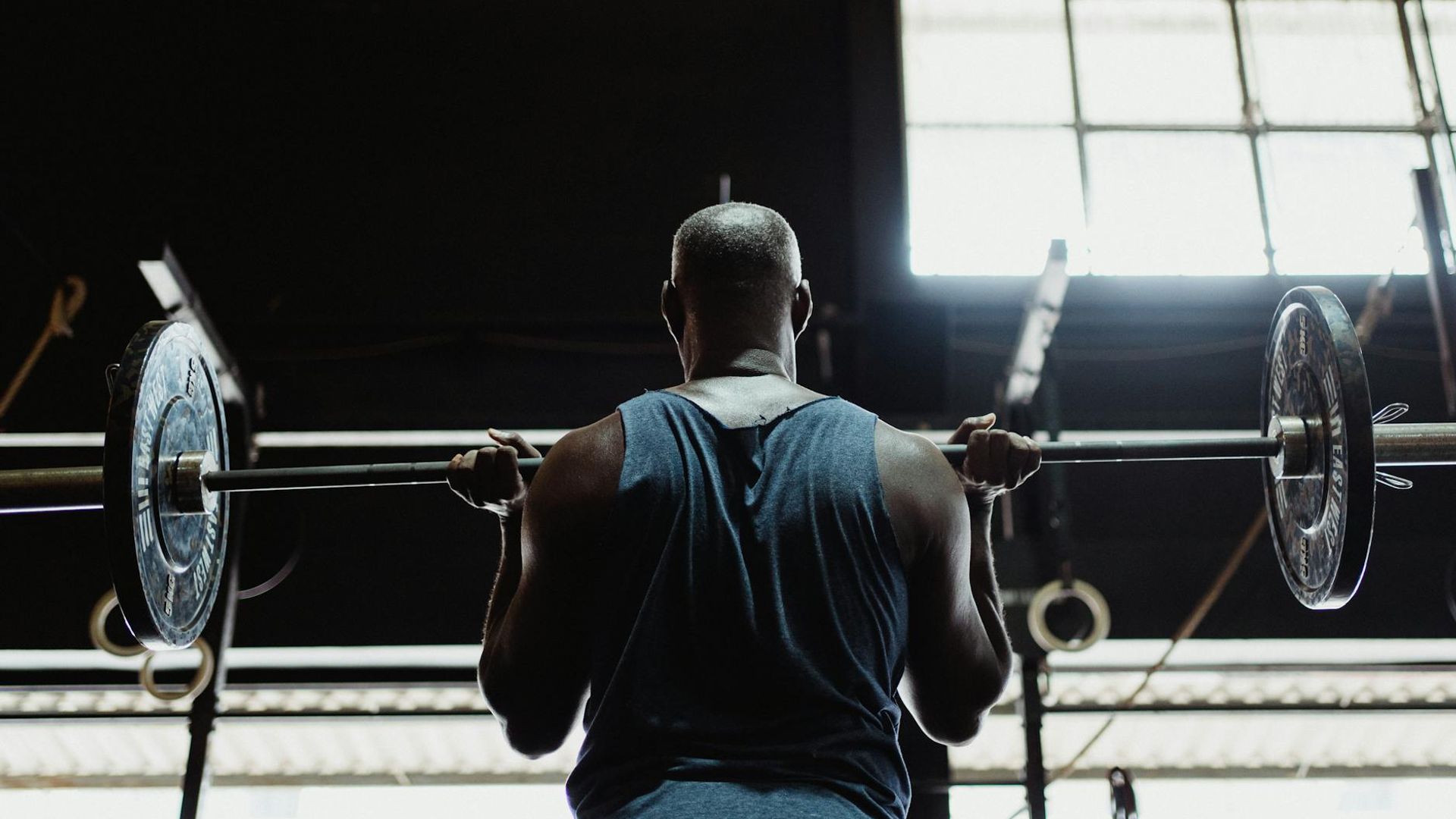Male athlete training in a dark atmospheric gym environment