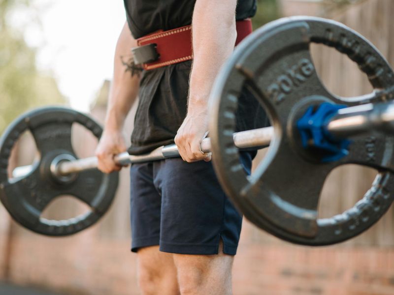 Professional athlete hands gripping a heavy barbell bar